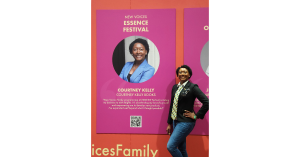 A person is standing next to an image of themselves on a wall with a headshot followed by a quote