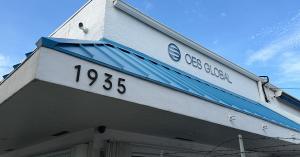 Exterior of the OES Global Inc headquarters building, marked 1935, with the company logo under a clear blue sky.
