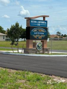 Monument sign for Hector A. Cafferata Jr. K-8 School, featuring the school name, a digital display with the school's design logo, and the school emblem, set along a roadway near the campus.