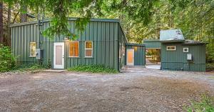 Green buildings surrounded by redwoods at Redemption Canyon in Sebastopol, California.