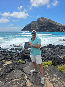 Author Ray Culver with his debut novel H2ONU: The First Edition on the Makapuʻu coast, Oʻahu.