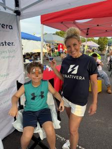 Janae Tanner of Strativera holds a paintbrush at the agency's face-painting station during Evesham Township's National Night Out