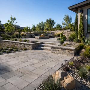 Tiered backyard hardscape renovation in Folsom, California with paver patio, stacked stone retaining walls, built-in fire pit, and drought-tolerant landscaping