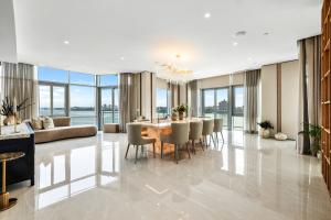 Spacious dining room inside the 1000 Portside Drive penthouse in Edgewater, New Jersey, with a crystal chandelier, marble floors and floor-to-ceiling windows overlooking the Hudson River.