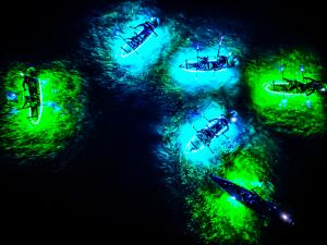 GlowRow kayaks putting out 20,000 lumens of light to see thru any type of water.  A over head view showing a spectacular moment where you can see the clear kayaks, the lights, and what lies beneath.