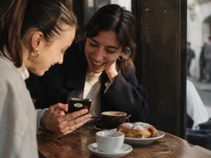 Two local creators sharing a recommendation at a neighborhood café as part of the Secret World community.