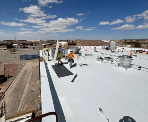JM Roofing and Construction technicians working on a commercial TPO flat roofing system project in El Paso, Texas.