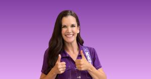 Kathryn Cloward as Kathryn the Grape, smiling while holding her signature purple acoustic guitar and wearing a coordinated purple outfit against a purple and lavender background. Cloward is an award-winning children’s recording artist, bestselling author,