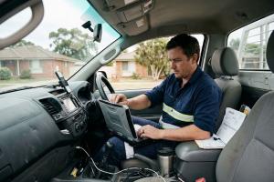 An Australian small business owner working from a laptop, representing the founders losing hours weekly to administrative tasks.
