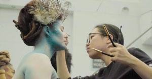 Makeup artist applying intricate makeup to a subject on a film set