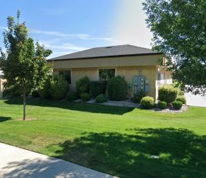 Exterior view of the Copper Canyon Law single-story office building in Star, Idaho, featuring a tan facade, surrounded by a well-maintained green lawn, trees, and landscaping on a sunny day.