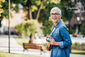 Happy traveler holding a camera