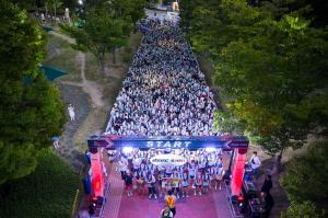 Participants walk along Busan's riverside during an all-night urban walking event. (Photo courtesy of Busan Metropolitan City)