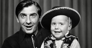Black-and-white photograph of a young Paul Rushworth-Brown smiling with his father, Jimmy Brown.