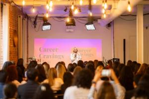 Irina Posan speaking on stage to a live audience at a Career Cravings event