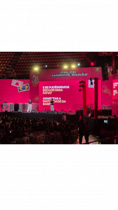 A picture of a stage at the Junior Enterprises World Conference that is presenting a red presentation