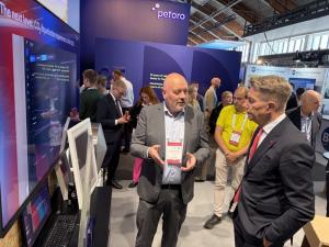 Norway's Minister of Energy, Terje Aasland, speaks to Enerin Co-founder and Head of Concept Design, Trond-Atle Asphjell, after the award ceremony. They are standing in a big hall at the Offshore Northern Seas (ONS) Forum surrounded by many people.