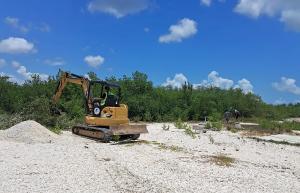 Workers use heavy machinery to clear the construction site.