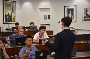 Zachary Schwartz explains financial literacy concepts to student