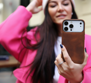 O2 Leather has launched its new leather iPhone 18 wallet cases Woman holding an iPhone 18 Pro with a brown O2 Leather leather case.