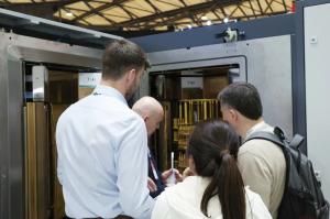 International visitors examining a Huasheng coating system at the exhibition.