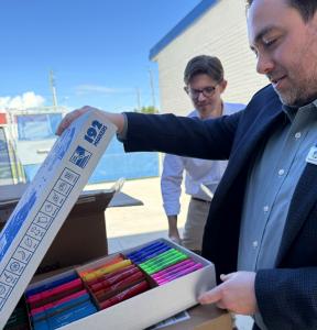 Guys unloading boxes of art supplies