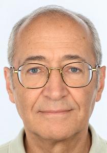 Portrait of author Nicolas Maftei, an older man with grey hair and gold-rimmed glasses.
