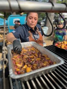 Chef Grecia Ramos cooking over a live-fire grill.