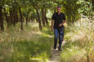 Four months after announcing its founding clinical partners, REEV's Neuro-Integration Program (NIP) doubled in size, bringing the total number of signed clinical partners to six and counting A man walking outside wearing a lightweight robotic leg KAFO from REEV.