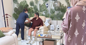 R3 Life clinical team member attending to a seated guest in a private treatment lounge