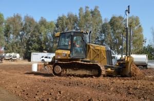 Heavy machinery performing professional grading and site excavation services for commercial pavement preparation.