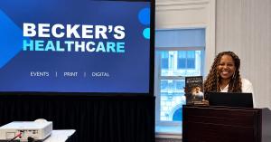 Dental automation speaker Dr. Catrise Austin holding The Dental Exit Blueprint at a Becker's Healthcare event in Chicago.