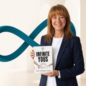 Author Sandy Wardenburg Waggett holding her book Infinite Yous in front of a teal infinity symbol.