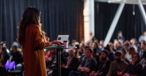 Victoria Tran speaking on stage to a seated audience at the Montréal International Game Summit.