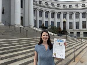 Denver Mayor Mike Johnston has proclaimed September 21, 2026, as Executive Director Lauren Coffaro holds the proclamation by Denver's Mayor.