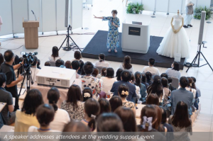 A speaker addresses attendees at the wedding support event
