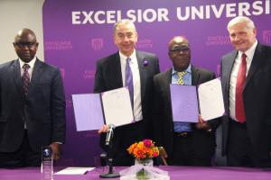 Four men pose with signed partnership agreement documents.