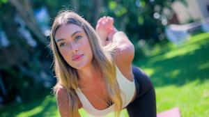 Joana Rita (@jooritaa) practicing yoga outdoors in the gardens of Falésia Hotel in the Algarve, surrounded by greenery and natural light.