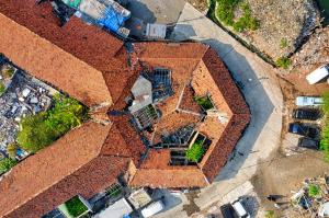 State insurance regulators in Connecticut, New Hampshire, and Pennsylvania have told insurers that aerial imagery alone is not sufficient grounds to decline to renew a property insurance policy, and New York is considering legislation to set formal standards for how insurers use drone and satellite imagery in underwriting decisions An aerial drone photograph looking straight down at a red-tiled rooftop showing visible damage and construction debris s