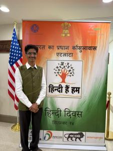 Hiten Bhuta standing beside Hindi Divas display at the Consulate General of India in Atlanta