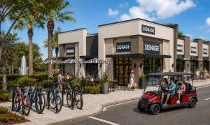 Architectural rendering of Oakland Village storefronts with bike racks and dedicated golf cart parking, designed for easy access from nearby neighborhoods and trails.