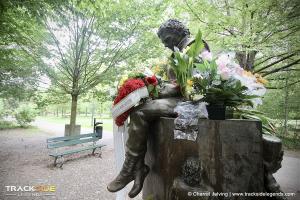 Colour photo (side view) of Ayrton Senna memorial statue, decorated with fresh flowers