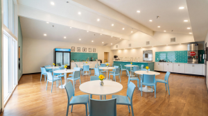 spacious cafeteria with matching white tables and light blue chairs, drinks and snacks