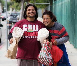 Happy Cash for Trash participants with their new blankets and Christmas-colored bags of hygiene supplies and toiletries.
