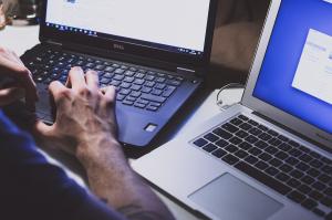 Two hands on two Laptops with different Systems