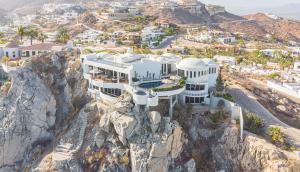 Cliff House, an immense multi-room estate, nestles about the Sea of Cortez and the Pacific Ocean. The pool has views of the large bodies of waters.