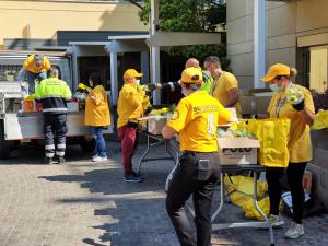 In the courtyard of the Church of Scientology Milan, Pro.civi.co.s volunteers collect and sort fresh fruit and vegetables for distribution to those in need.