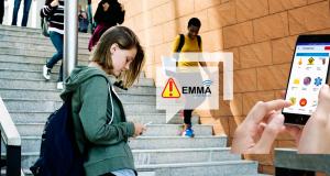 A high-school girl is looking at an EMMA alert on her phone.