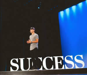 Peter Voogd on stage talking about business success.