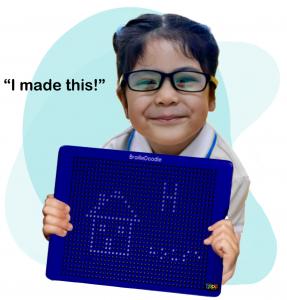 Young Hispanic girl, in a white blouse and black and yellow glasses, ​is smiling, about ​5​ . She is holding the BrailleDoodle which is a house,  a capital letter each, and the word house in braille... The quote says, "I made this!"